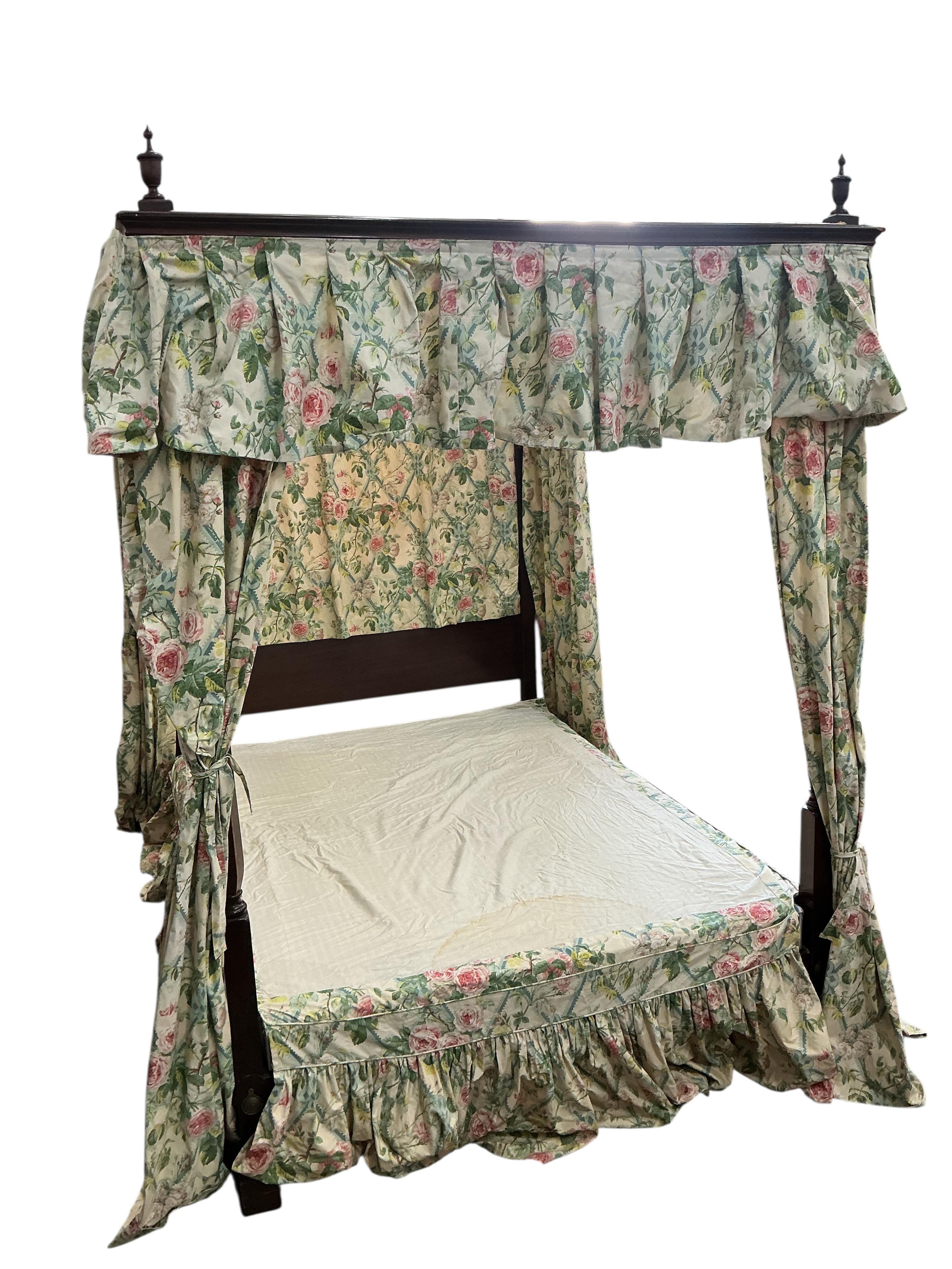 A George III style mahogany four poster bed, with floral drapes, width 150cm, length 208cm, height 220cm